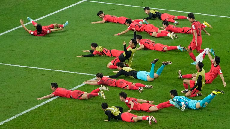 South Korea&#39;s players celebrate after qualifying for the Round of 16 with a 2-1 defeat of Portugal