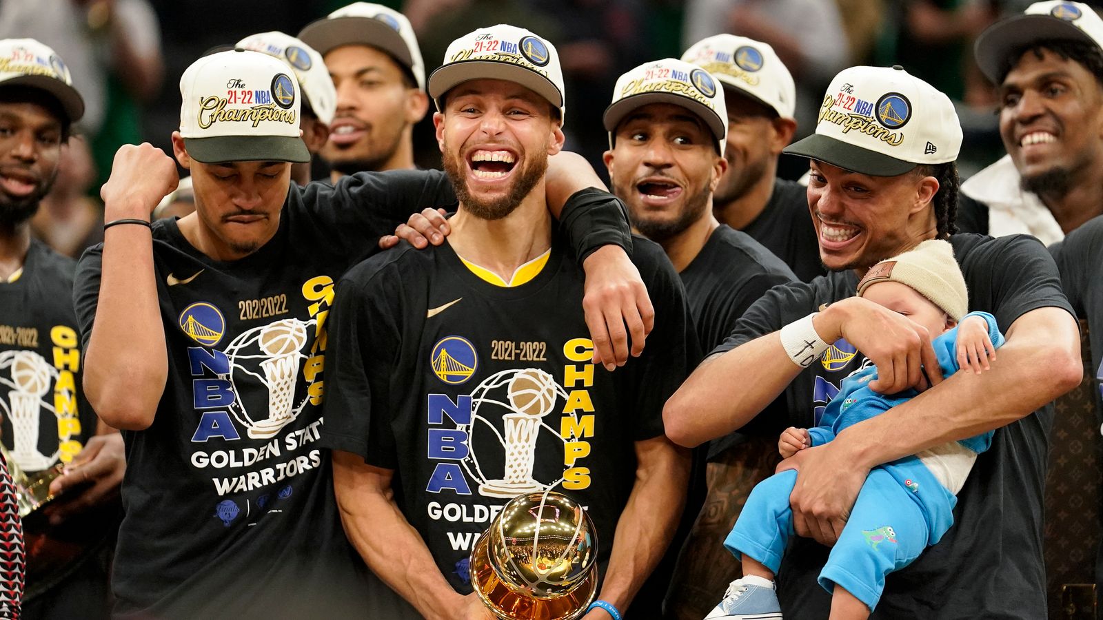 Golden State Warriors guard Steph Curry, center, celebrates with team-mates as he holds the Bill Russell Trophy for Most Valuable Player